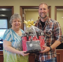 Prize winner holding gift basket.